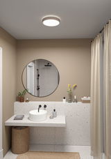 Rundes Deckenlicht mit Stoffrand in Beige beleuchtet modernes Badezimmer mit Terrazzo-Waschtisch.