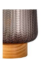 Close-up of brown glass lampshade with herringbone pattern on light wood base, decorative lighting