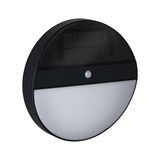 Round black solar wall light with motion sensor and white diffuser for outdoor lighting