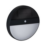 Round black solar wall light with motion sensor and white diffuser for outdoor lighting