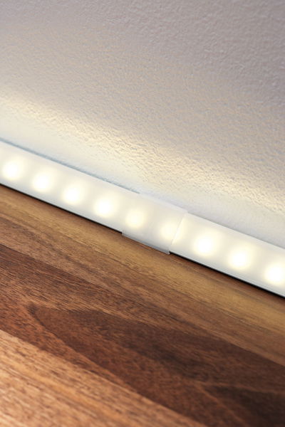 Weiße LED-Lichtleiste mit warmweißem Licht auf Holzoberfläche für moderne Raumbeleuchtung