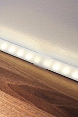Weiße LED-Lichtleiste mit warmweißem Licht auf Holzoberfläche für moderne Raumbeleuchtung
