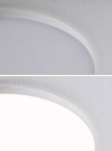 Close-up of round white LED ceiling light with fine edge and textured ceiling surface