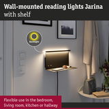 Wall-mounted Jarina reading light in black with shelf and warm white LED backlight for flexible room lighting