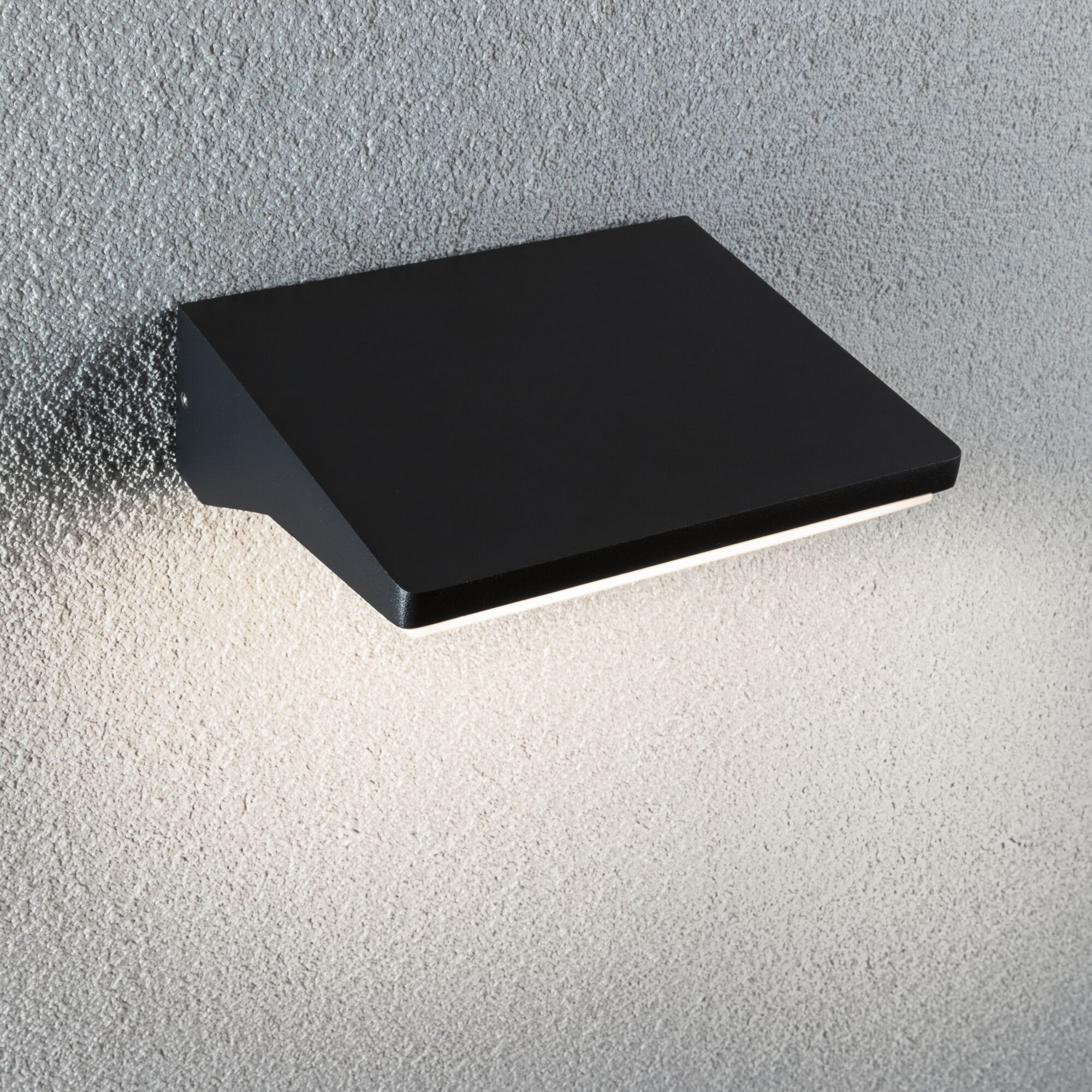 Schwarze Wandlampe aus Metall mit modernem Design an strukturierter grauer Wandbeleuchtung
