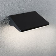 Black metal wall light with modern design mounted on textured grey wall for indoor lighting