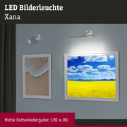 Weiße LED-Bilderleuchte Xana aus Metall an blauer Wand mit Kunstwerken und hoher Farbwiedergabe CRI ≥ 90
