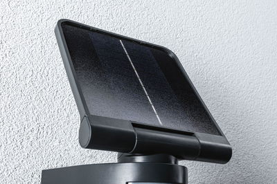 Black solar panel with plastic frame mounted on wall for sustainable lighting solution