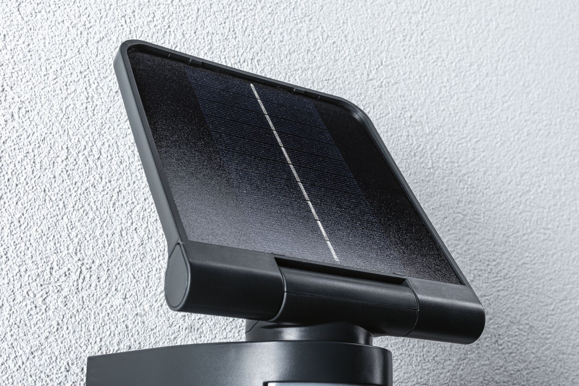 Schwarzes Solarpanel mit Kunststoffrahmen an weißer Wand montiert für nachhaltige Energiegewinnung