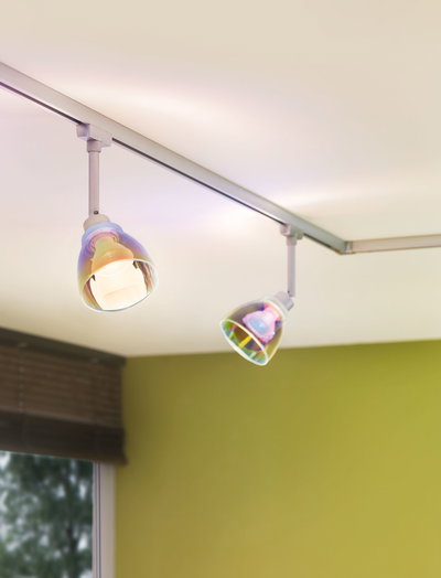 Two adjustable ceiling spotlights with transparent iridescent glass shades in a modern living space.