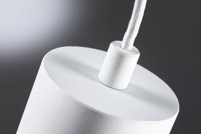 Close-up van witte gestructureerde lampfitting met stoffen kabel voor moderne LED-verlichting
