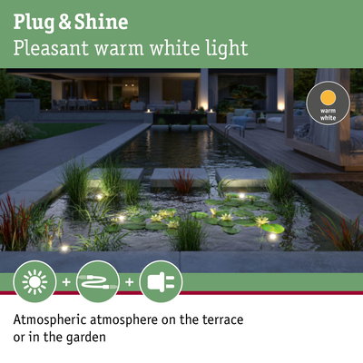 Warm white LED garden lights create atmospheric lighting on terrace and pond area
