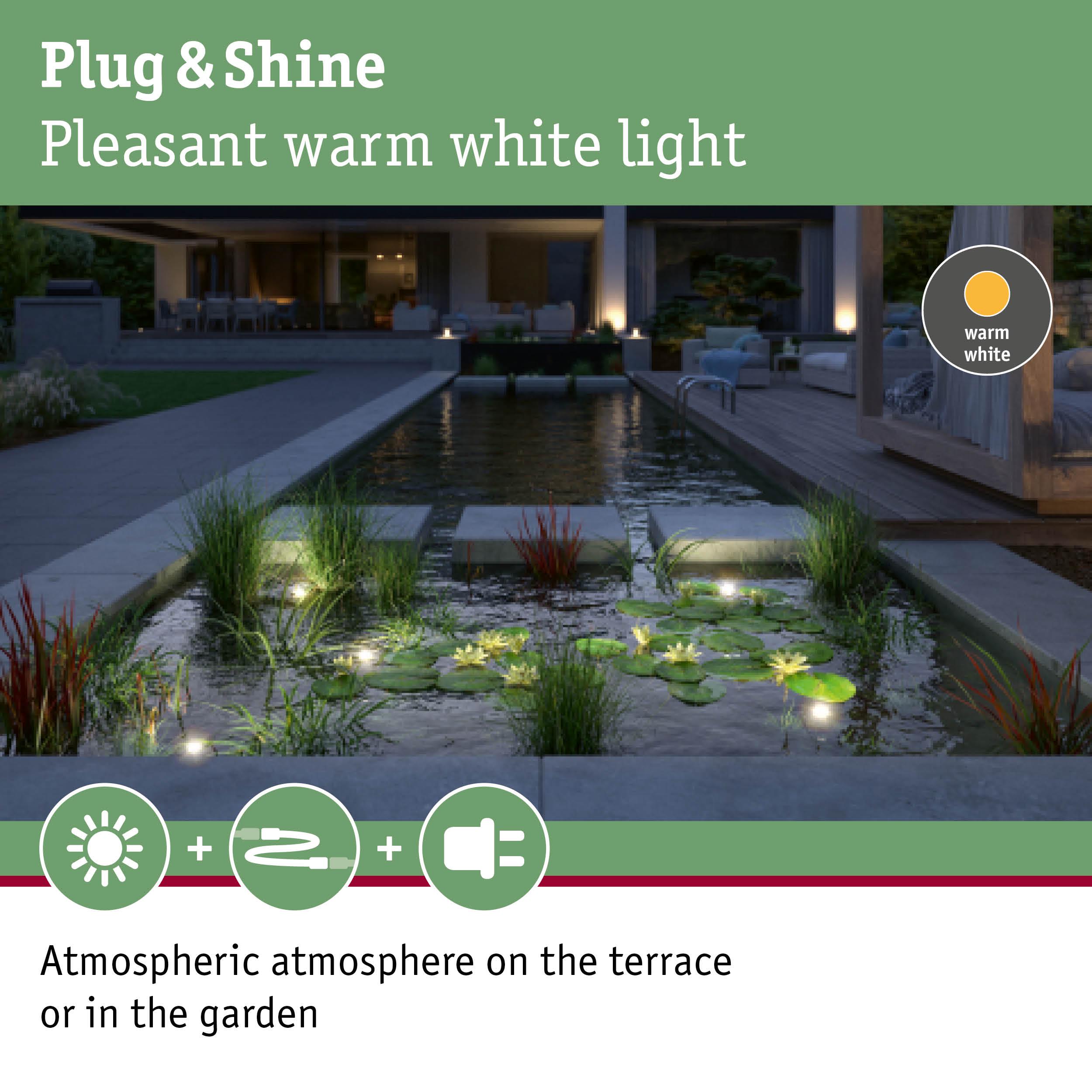 Warm white LED garden lights create atmospheric lighting on terrace and pond area