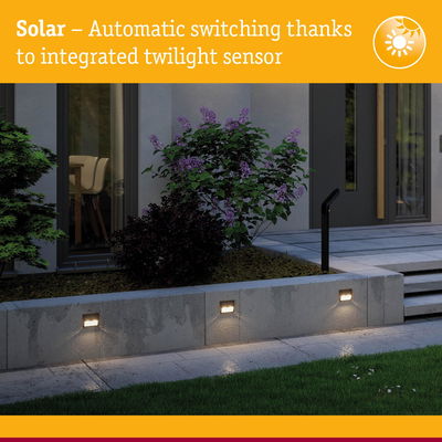 Solar outdoor wall lights with integrated twilight sensor mounted on grey concrete wall in garden