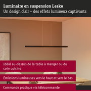 Luminaire suspendu Lesko noir en métal au-dessus d'une table en bois clair dans une salle à manger moderne