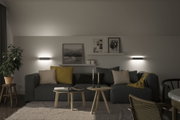 Modern living room with grey sofa, yellow and beige cushions, wooden tables and wall lights for ambient lighting