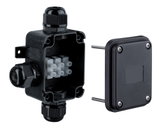 Black plastic junction box with screw caps and white terminal block for electrical connections