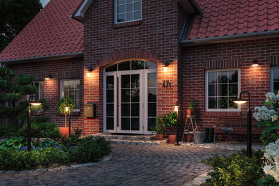 Illuminated red brick house entrance with modern black outdoor lights for garden and patio lighting