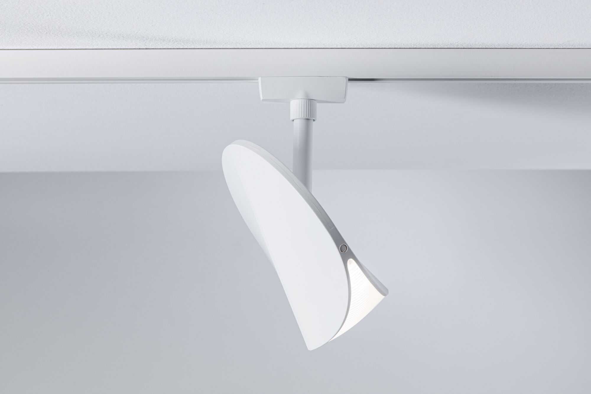 Moderner weißer LED-Spot aus Kunststoff an Schienensystem für flexible Raumbeleuchtung