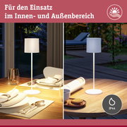 Weiße Stehlampe mit Stoffschirm auf Holztisch, geeignet für Innen- und Außenbereich mit IP44 Schutz