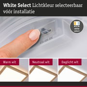 Vinger stelt witte lichtkleur in op LED-plafondpaneel met houten frame voor woonverlichting