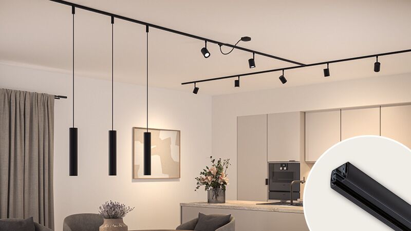 Rail d'éclairage URail noir mat avec plusieurs spots et suspensions dans un intérieur moderne.