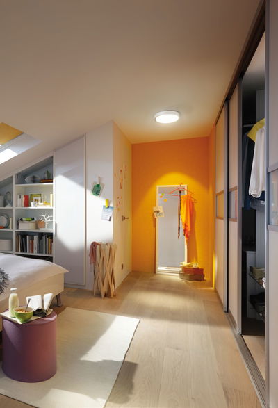 Moderne slaapkamer met lichte houten vloer, wit meubilair en plafondlamp voor warme verlichting.