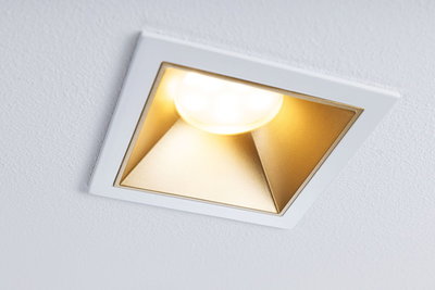 Quadratischer Einbaustrahler mit weißem Rahmen und goldfarbenem Reflektor für warmes LED-Licht