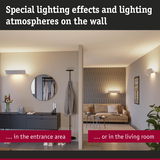 Modern white wall lights with warm glow create special lighting effects in entrance and living room.