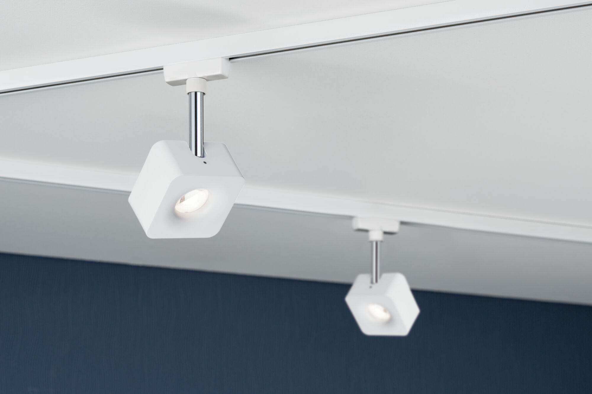 Weißer LED-Deckenspot aus Kunststoff mit verchromtem Stab an Schienensystem für moderne Raumbeleuchtung