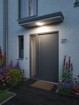 Modern anthracite front door with large handle and LED ceiling light illuminating the entrance area.