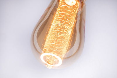 Nahaufnahme einer warmweißen LED-Glühbirne mit dekorativem Lichtmuster und bernsteinfarbenem Glas