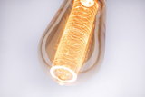 Gros plan d'une ampoule LED blanc chaud avec motif lumineux décoratif et verre ambré