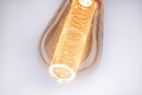 Close-up van warmwitte LED-lamp met decoratief lichtpatroon en amberkleurig glas