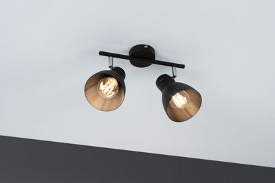 Sort loftlampe med to justerbare metalspots og varmt hvidt lys til opholdsrum.
