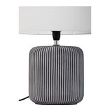 Lampe de table moderne avec base en céramique grise rainurée et abat-jour en tissu blanc.