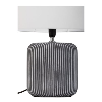Lampe de table moderne avec base en céramique grise rainurée et abat-jour en tissu blanc.