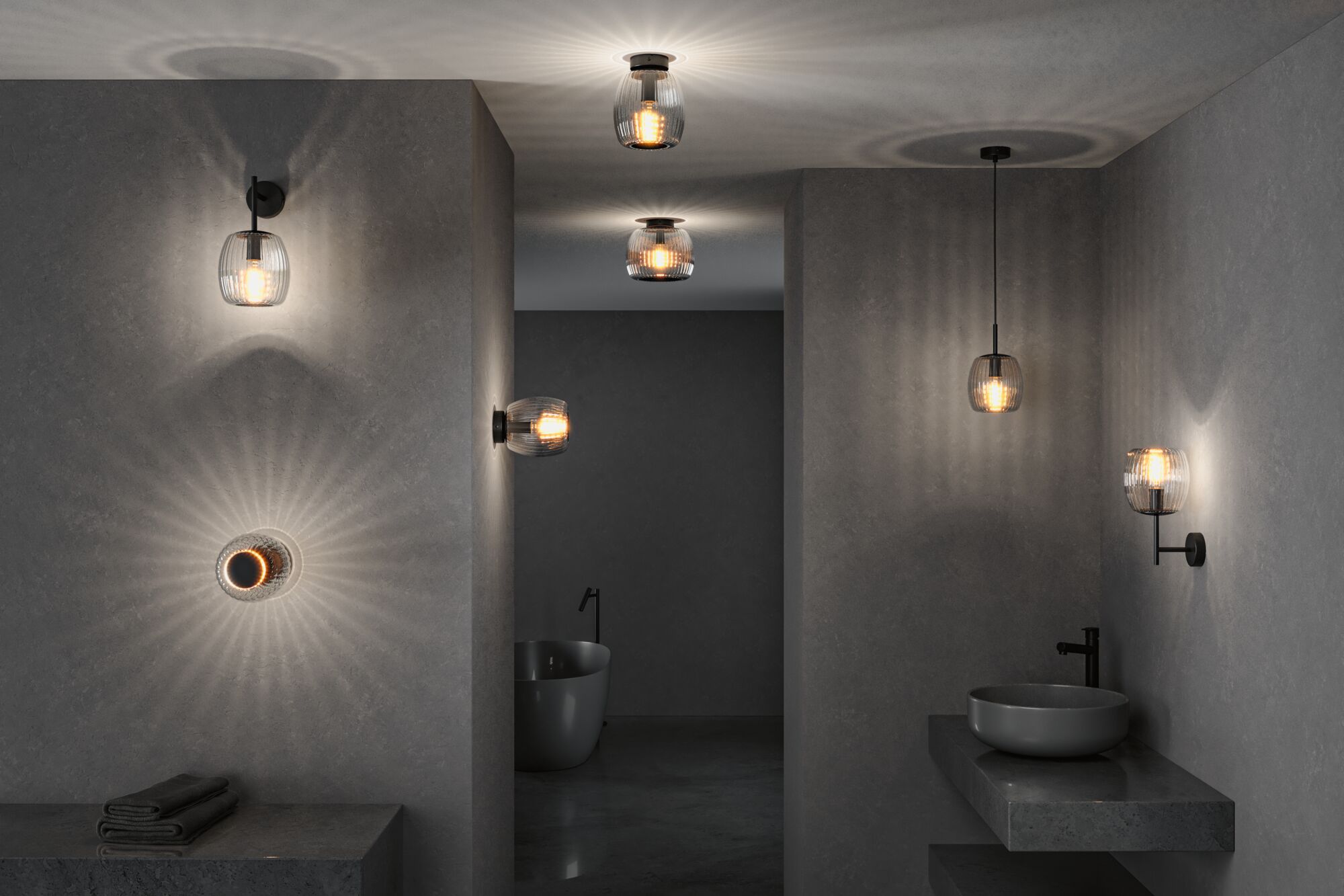 Modern bathroom lighting with black metal fixtures and ribbed glass shades creating ambient light effects.