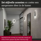 Moderne hal met geometrische zwarte en witte wandlampen en spiegel voor stijlvolle accenten