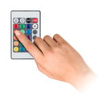 Main utilisant une télécommande colorée pour régler la couleur et le mode des lumières LED.