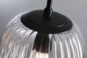 Close-up of clear ribbed glass pendant light with black metal holder for modern interior lighting