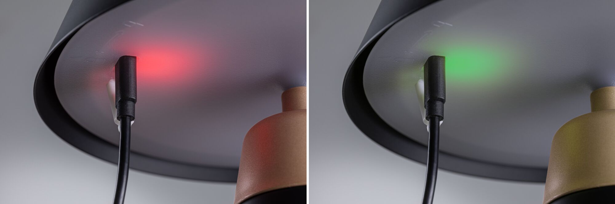 Nahaufnahme eines schwarzen Kabelanschlusses an einer grauen Lampenhalterung mit rotem und grünem Licht