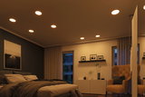 Modern bedroom with warm white LED recessed lights in ceiling providing cozy ambient lighting
