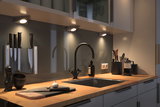 Moderne Küchenarbeitsplatte mit Holz, schwarzer Spüle, Armatur und LED-Unterbauleuchten für Küchenbeleuchtung.