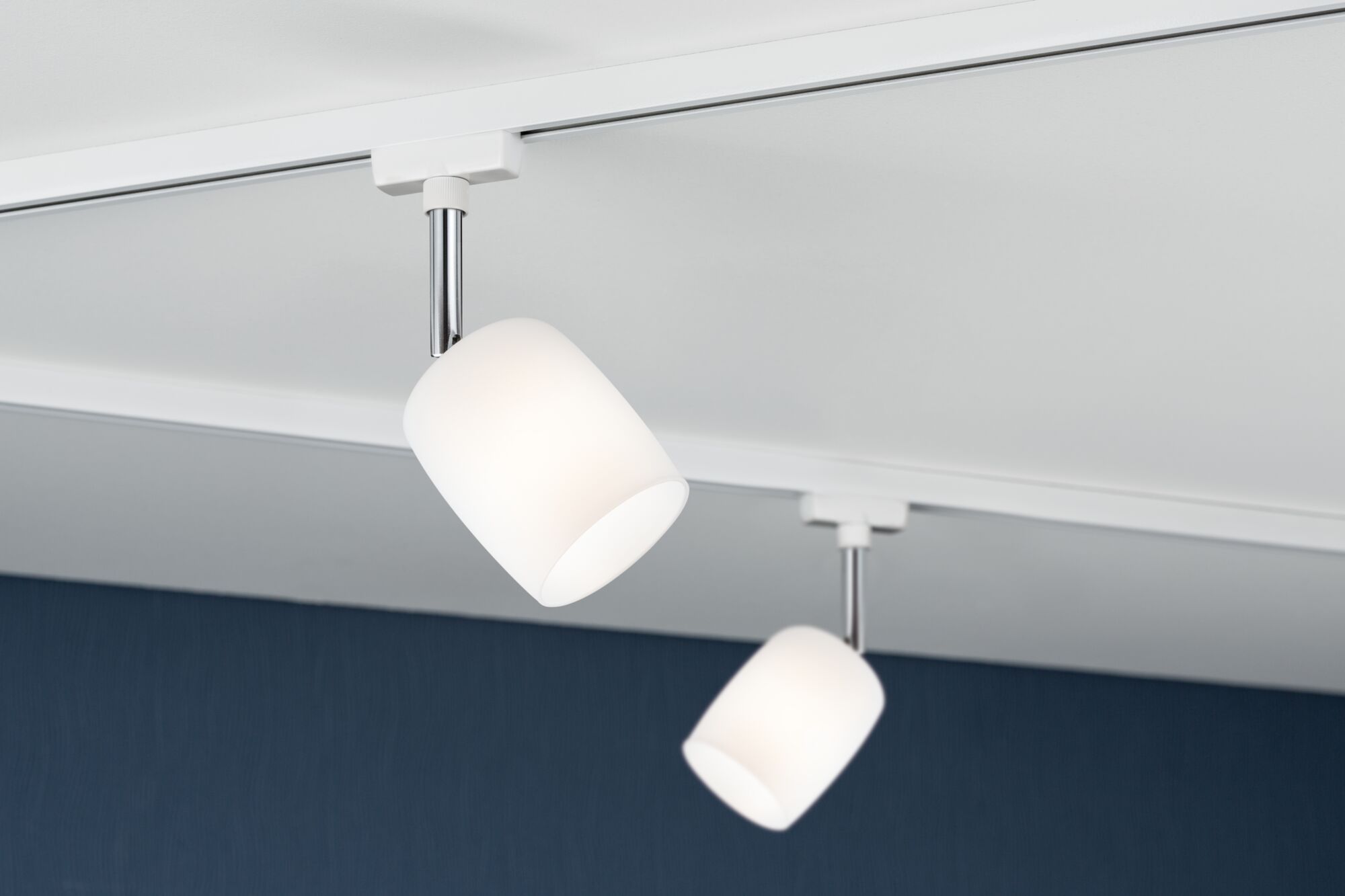 Deux spots de plafond en verre blanc avec tiges chromées sur rail blanc pour éclairage intérieur moderne