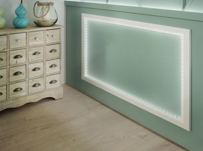 Éclairage cadre LED blanc sur mur vert avec meuble en bois et décoration dans salon moderne