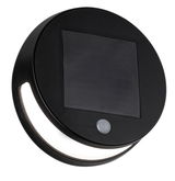 Round black solar light with motion sensor and integrated LED for outdoor use