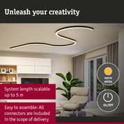 Black curved LED ceiling light with warm white illumination in a modern living room setting