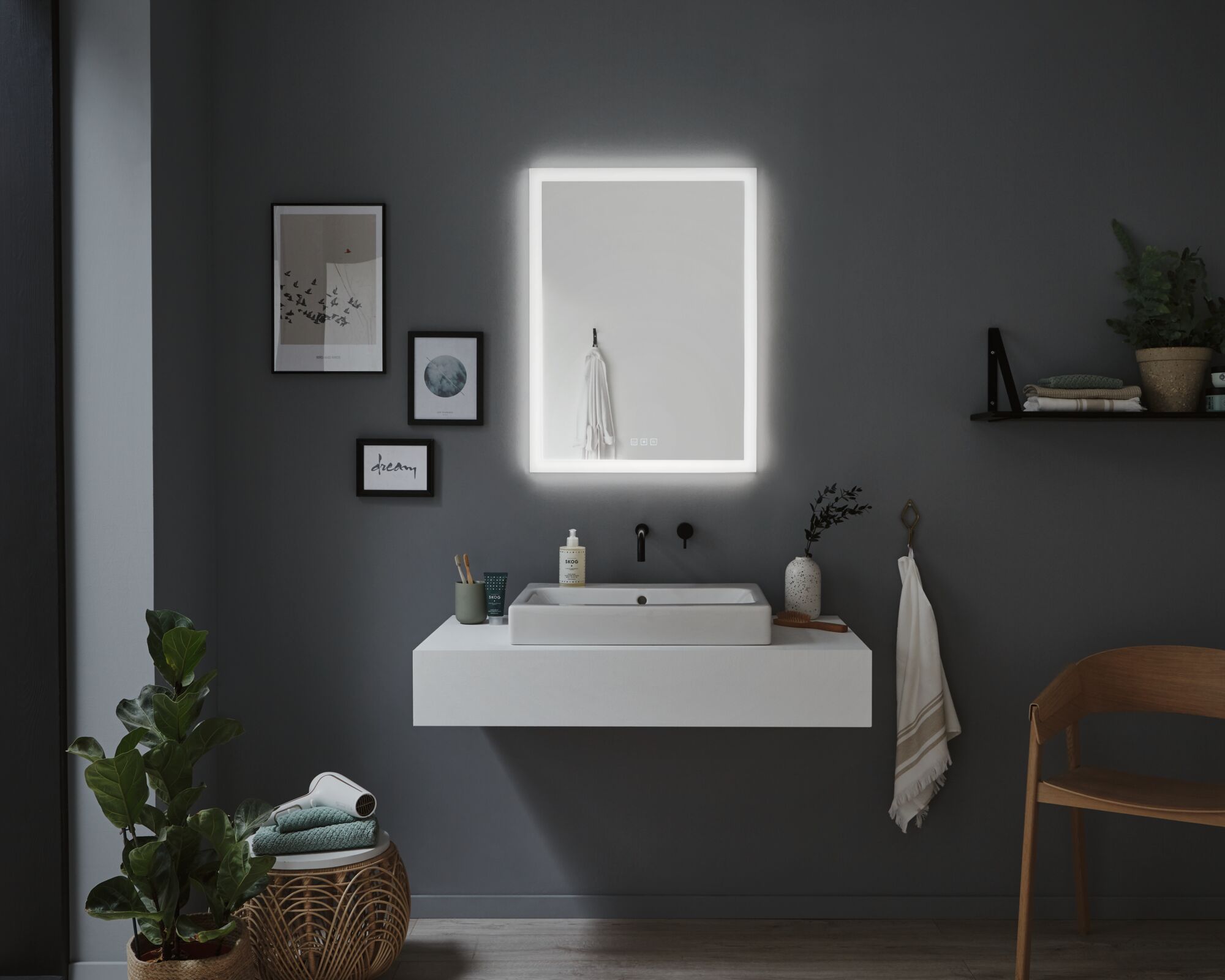 Salle de bain moderne avec miroir rectangulaire éclairé et lavabo en céramique blanche sur mur gris