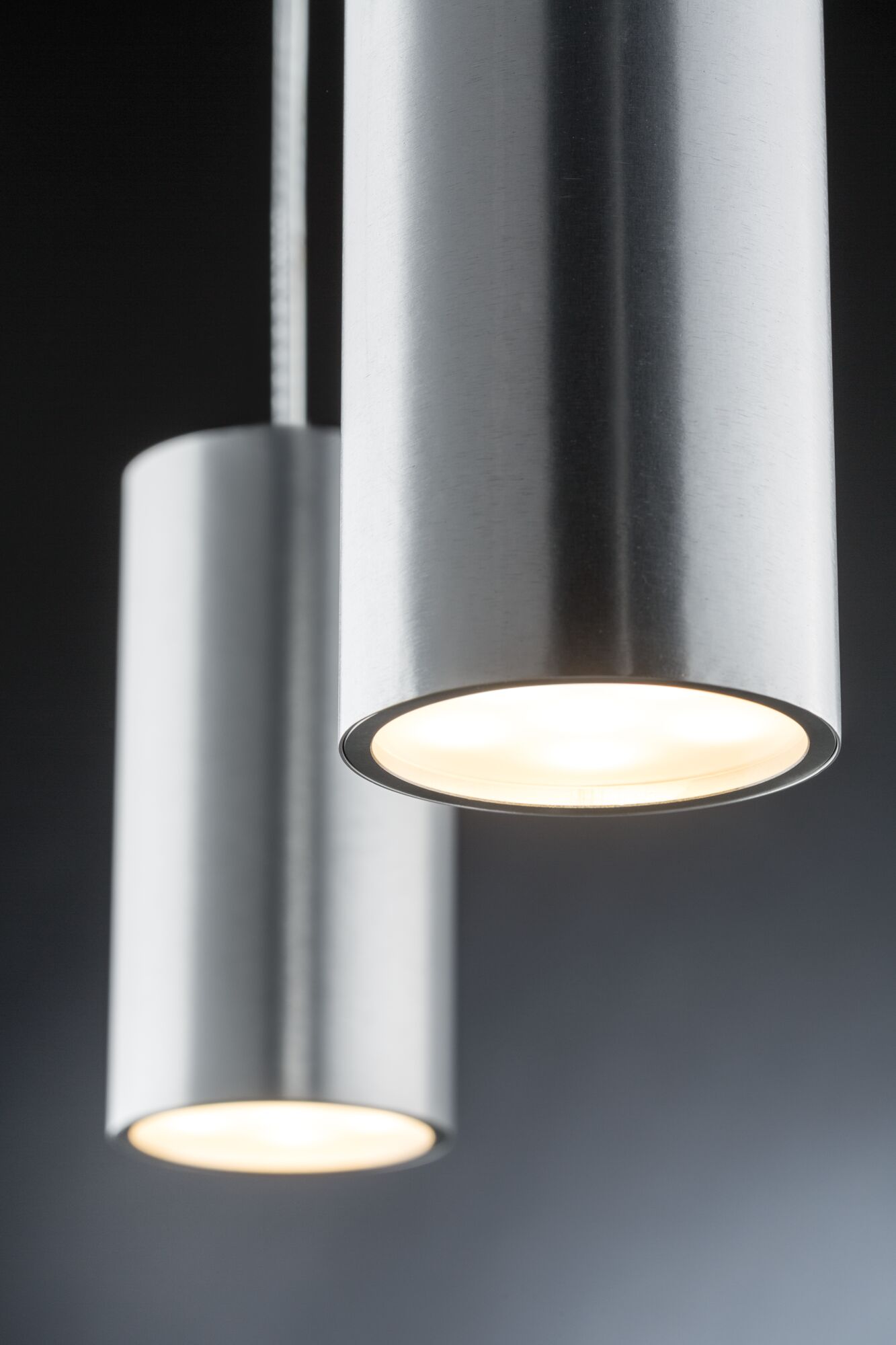 Twee cilindervormige LED-hanglampen van geborsteld zilverkleurig aluminium voor modern interieur.